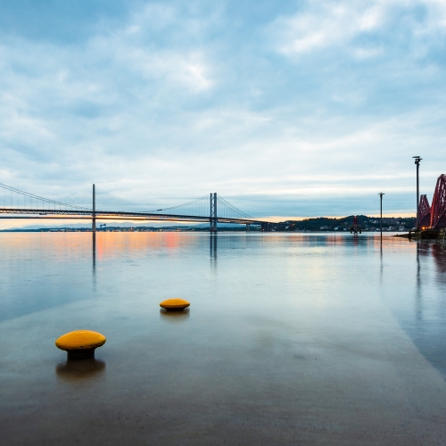 The tide washes over the Hawes Pier at South Queensferry with the Forth Bridges in the background, West Lothian, Scotland, United Kingdom. FB007