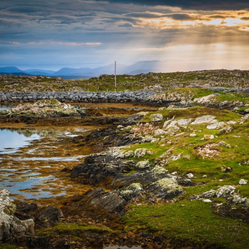 Sunburst over the Connemara mountains from Rossadillisk, County Galway.