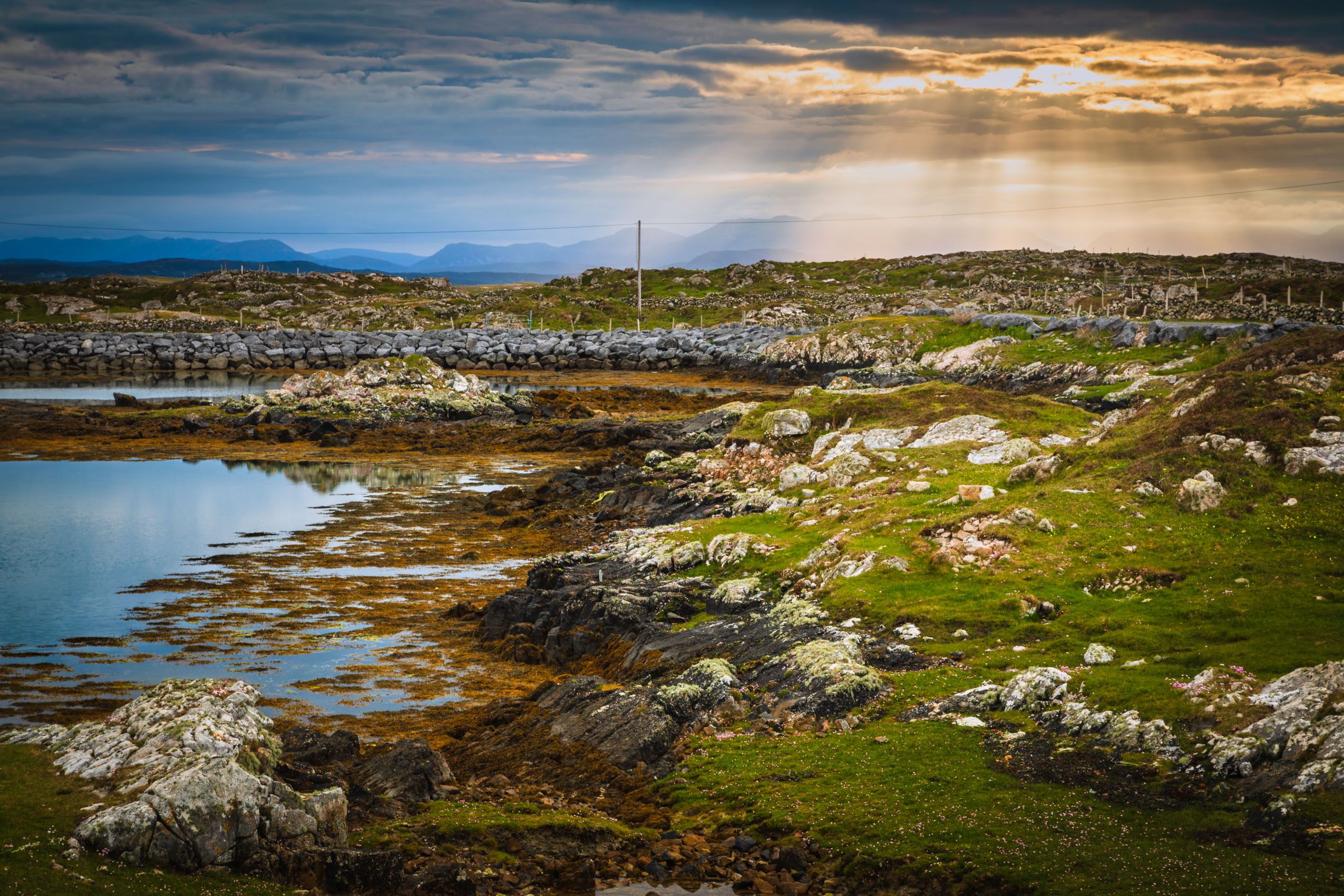 Sunburst over the Connemara mountains from Rossadillisk, County Galway.