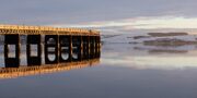 The Tay Railway Bridge lit by a low winter sun, Dundee, Scotland.