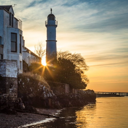 Sun setting behind Tayport West Lighthouse on the Firth of Tay, Fife, Scotland RT003