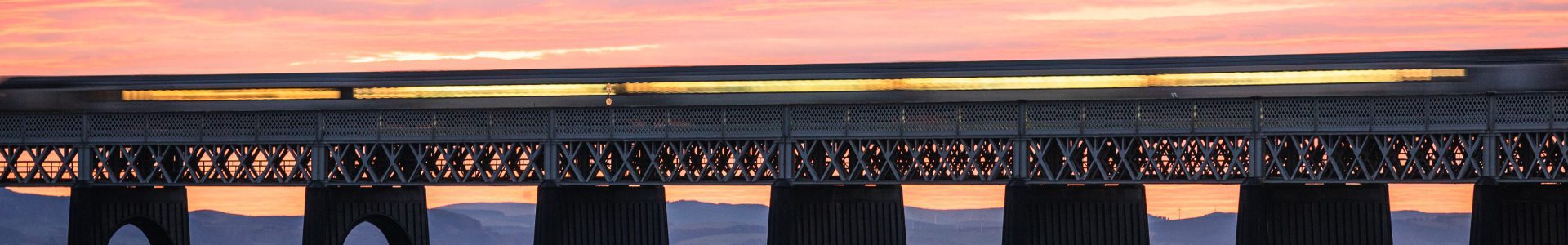 Train passing over the Tay Railway Bridge at sunset, Dundee, Scotland.